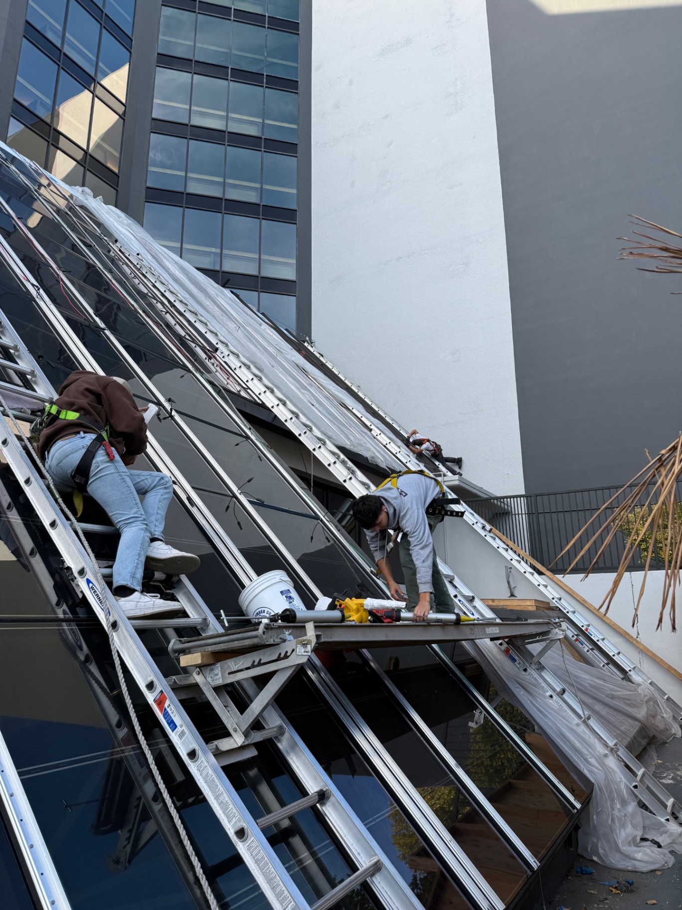 Two-person crew installing structural glazing panels